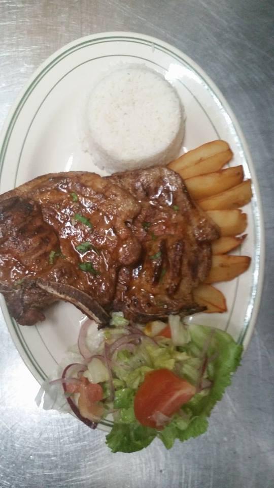 Chuleta a la Parrilla · Marinated pork chop with special sauce on the grill.