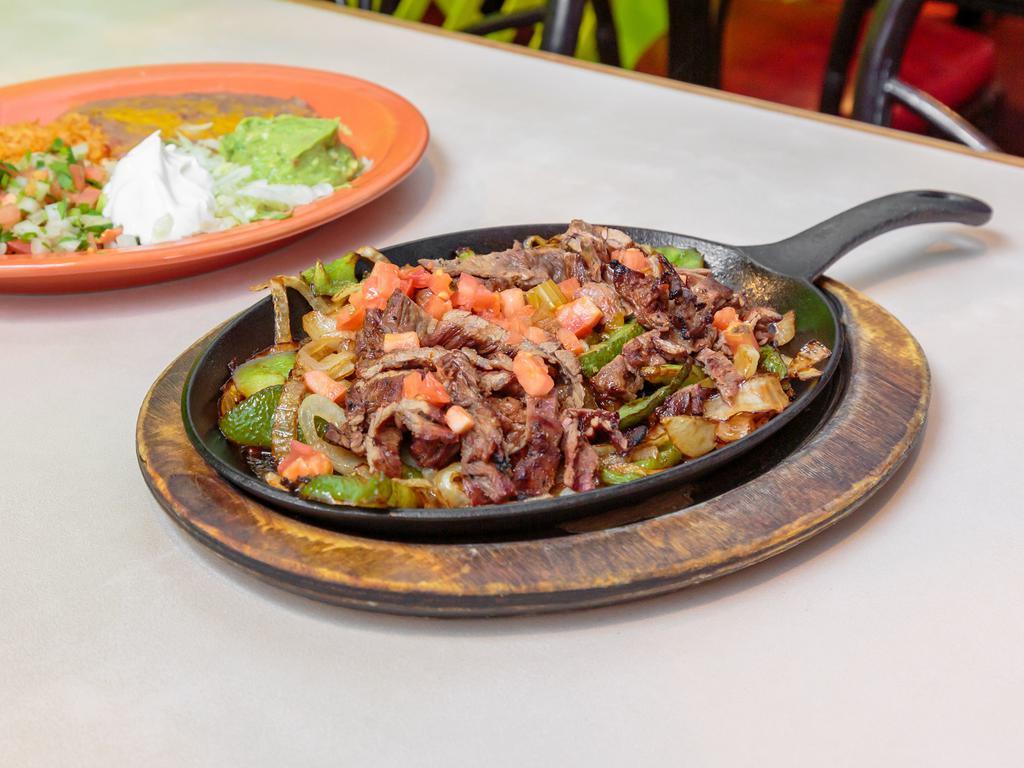 Steak Las Fajita · Beef marinated in secret sauce then served sizzling hot over a bed of sautéed onions and green peppers. Served with salsa ranchera, sour cream, guacamole, rice, beans, and tortillas.