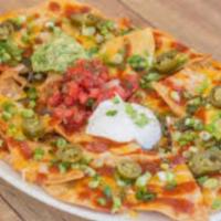 Nitrous Factory Nachos  · Crispy corn tortilla chips loaded and baked with ground beef, cheddar cheese, guacamole, sou...
