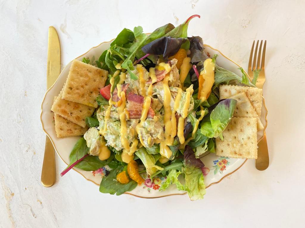 Chicken Avocado Salad · Scoop of chicken avocado salad on a bed of lettuce. Served with crackers. 

