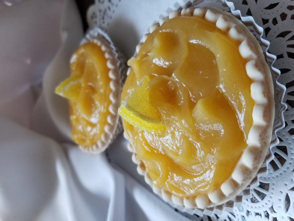 Lemon Tart · Lemon curd in a tart shell with a lemon wedge candy on top.