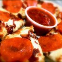 Ultimate North End Garlic Bread · Garlic bread topped with mozzarella, bacon, and pepperoni. Served with a side of marinara sa...