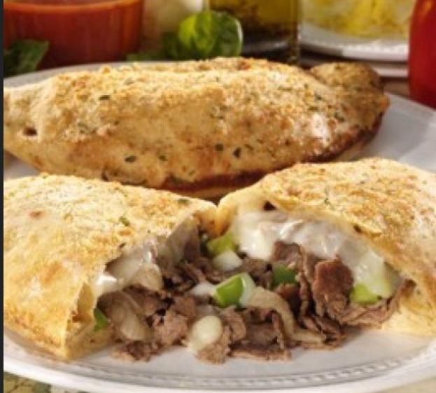 Philly Steak Calzone · Mushrooms, green peppers, onions, mozzarella, and juicy steak inside a calzone with a side of
homemade Philly dip.