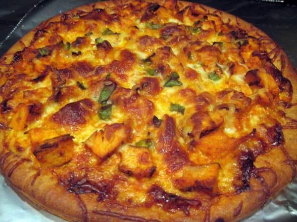 Achari Chicken Pizza · Desi achari flavor sauce, marinated chicken onion, bell pepper tomatoes. Light mozzarella cheese and cilantro