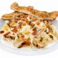 Fettuccine Alfredo · Grilled chicken strips, smoked bacon, Parmesan and gourmet cheese served over a bed of tende...