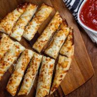 Cheesy Garlic Bread · Pizza dough topped with garlic and our three-cheese blend, baked and served with house-made ...