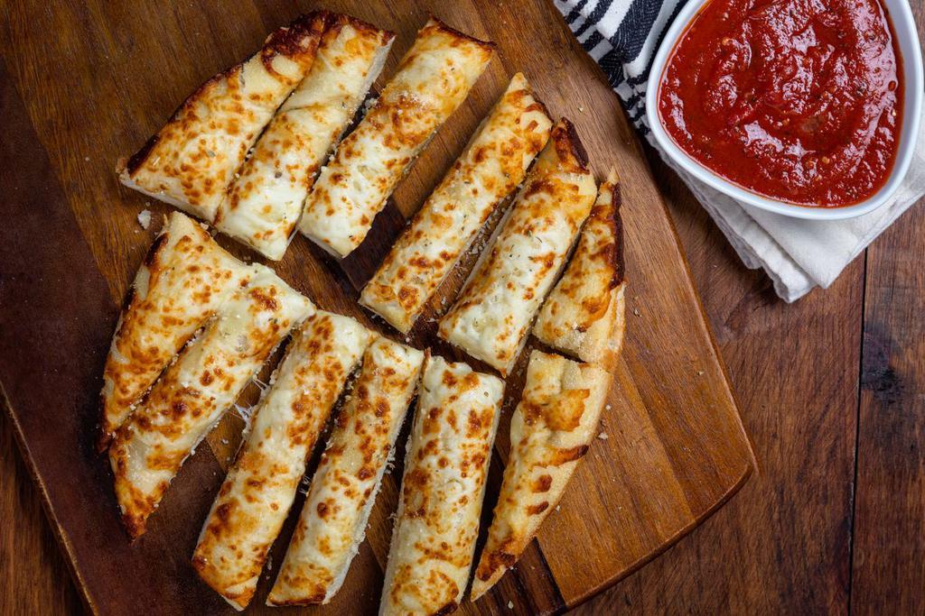 Cheesy Garlic Bread · Pizza dough topped with garlic and our three-cheese blend, baked and served with house-made marinara