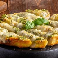 Cheesy Garlic Pesto Bread · Pizza dough topped with garlic and our three-cheese blend, baked and served with house-made ...