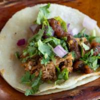 Carnitas Taco · In-house slow cooked pulled pork, cilantro, salsa roja and onion.