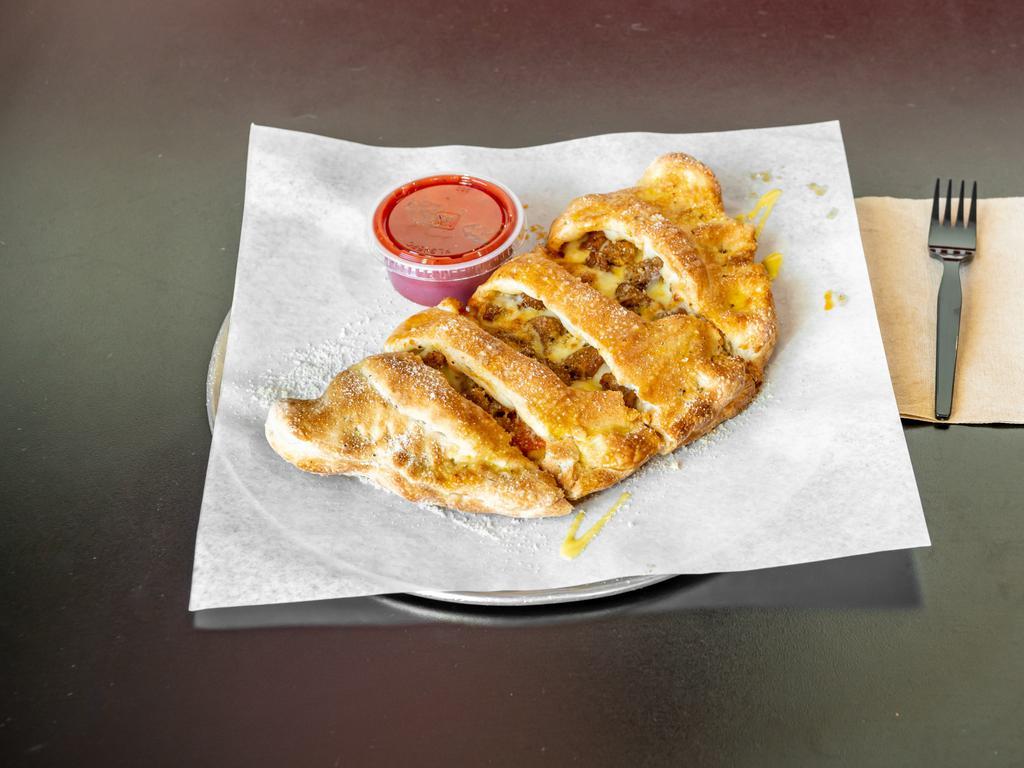 Large Supreme Calzone · Signature dressing, pepperoni, ham, sausage, mushrooms, onions, green peppers, black olives and mozzarella cheese. Wrapped in baked golden brown pizza dough. Topped with butter and Parmesan cheese. Served with a side of pizza sauce.