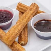 Churro Sticks · Four cinnamon & sugar churros with chocolate and cranberry dipping sauces.