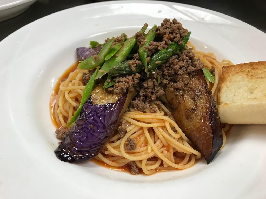 Eggplant and Spicy Ground Beef · Eggplant & spicy ground beef with asparagus in a tomato garlic oil sauce with spaghetti pasta. Served with garlic bread.