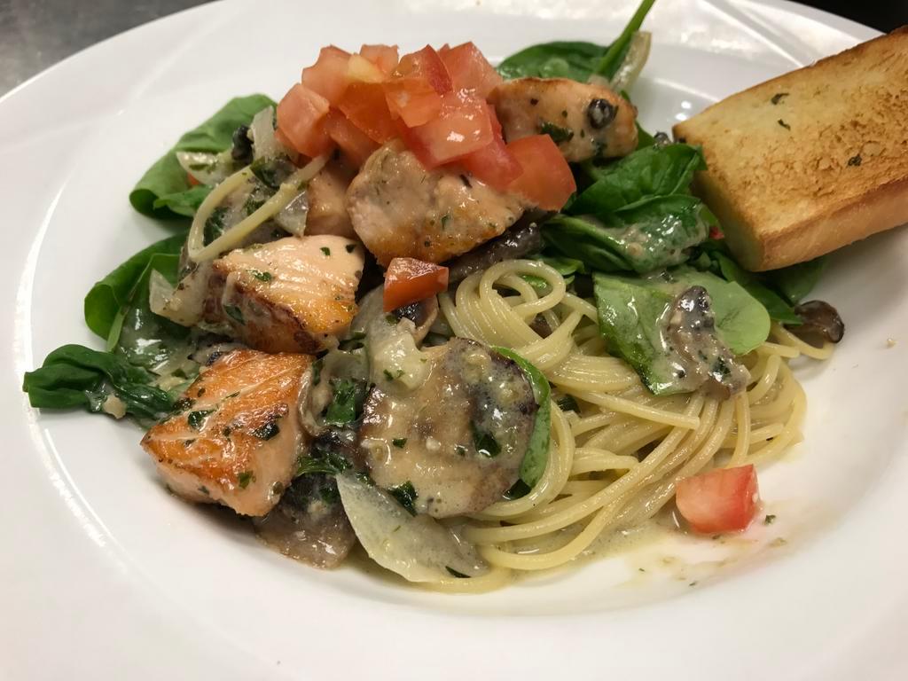 Salmon and Fresh Spinach Basil Cream · Salmon, fresh spinach, mushrooms, onions topped with tomato in a basil cream sauce with spaghetti pasta. Served with garlic bread.
