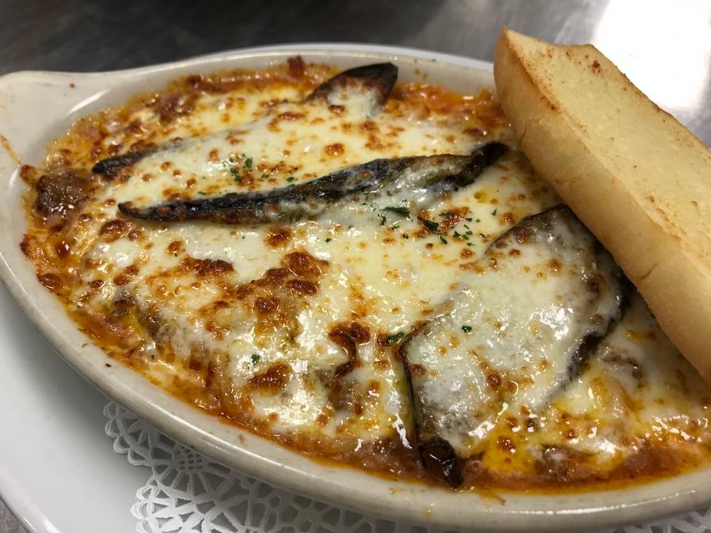 Meat Sauce and Eggplant Gratin · Bolognese sauce & eggplant over spaghetti pasta topped with mozzarella cheese then baked. Served with garlic bread.