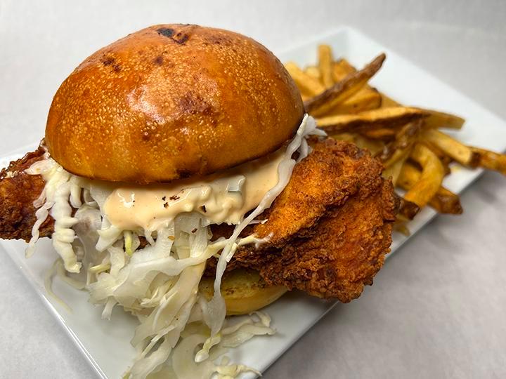 FRIED CHICKEN SANDWICH · pickle brined breast topped with jalapeno slaw, bread and butter pickles and tabasco aioli