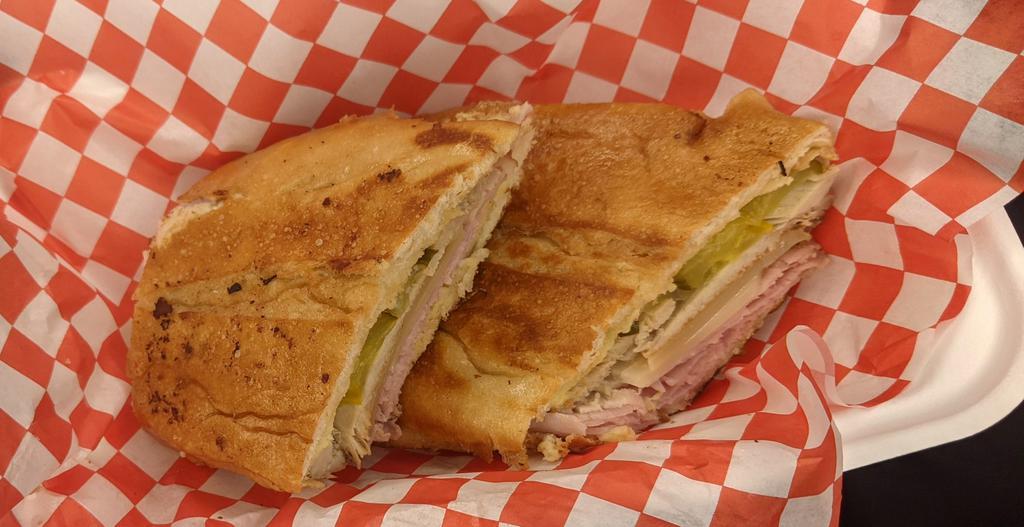 Maru's Cubano Sandwich · Our Cubano Sandwich is made on a roll layered with savory oven roasted pork, sliced ham off the bone, swiss cheese and pickles then pressed on the grill, This sandwich combo is serve with you choice of plantain Chips, sweet plantain or yuca fries. 