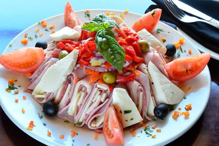 Antipasto Salad · Iceberg, romaine, ham, salami, provolone, fresh mozzarella, tomatoes, red onions, olives, roasted peppers, carrots, cucumbers, house vinaigrette dressing.