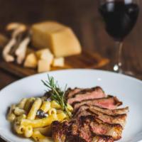 Tagliata · Sliced Angus beef steak with rosemary sauce and side of rigatoni in white truffle sauce.