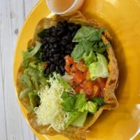 Crispy Taco Salad · Fresh romaine lettuce topped with black beans, shredded cheese, salsa fresca and guacamole s...