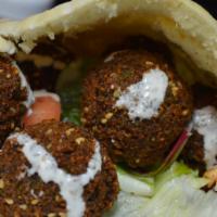 Falafel Sandwich · Hummus, lettuce, tomatoes, cucumber, pickles, hot sauce and tahini sauce. Served with your c...