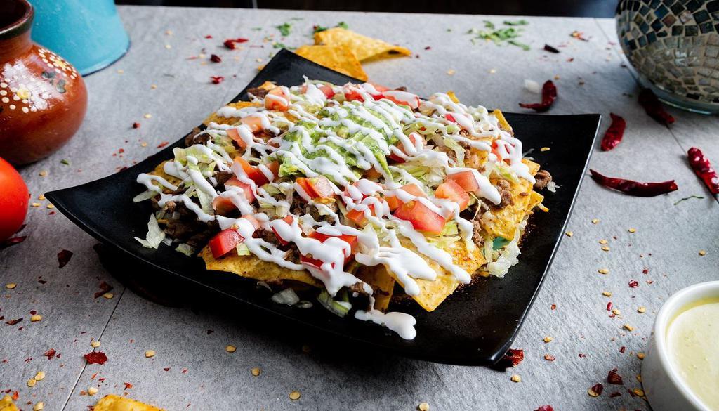 Nachos Supreme · Nacho supreme includes lettuce, tomato. Melted Mexican cheese, beans, guacamole,​ sour cream, and choose your protein.