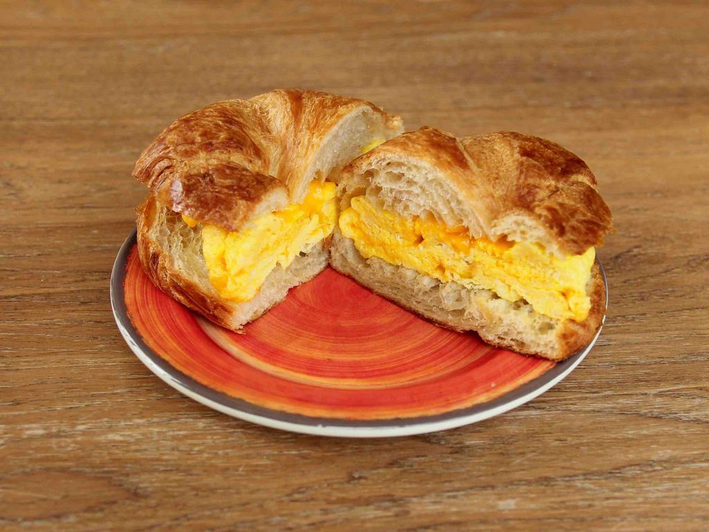 Egg and Cheese Croissant Sandwich · Two scrambled eggs with cheddar cheese on a butter croissant. Add ham, turkey or bacon for an additional charge.