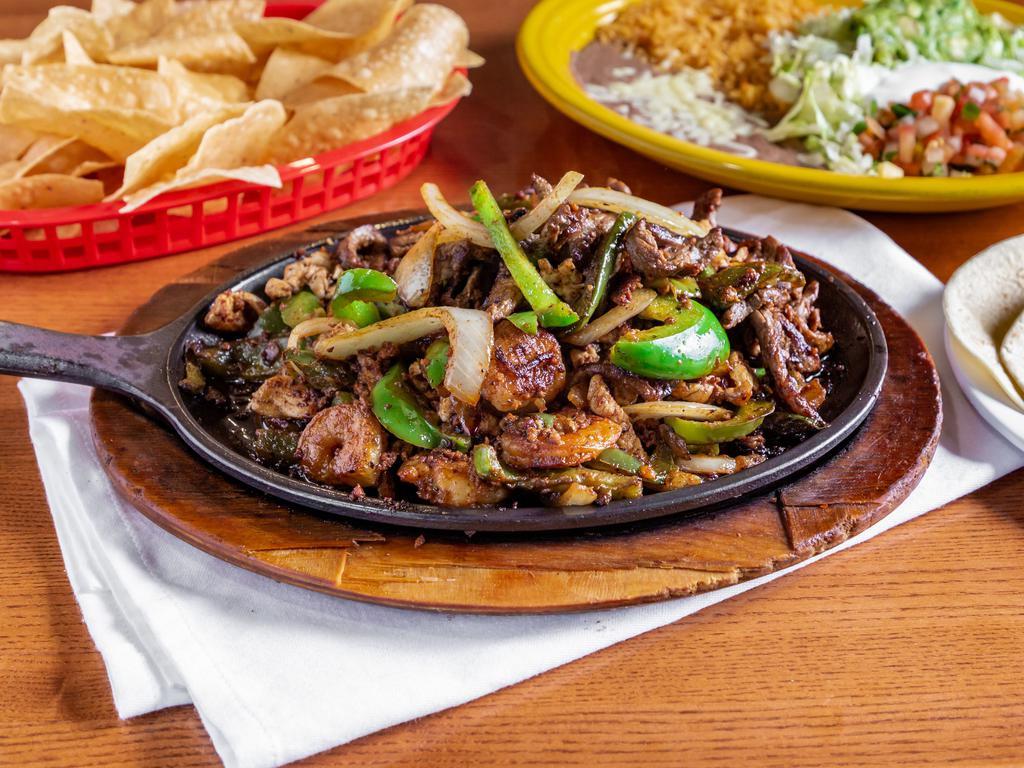 Fajitas La Fuente · Steak, chicken, chorizo, and shrimp grilled with bell peppers, tomatoes, and onions. Served with rice, beans, pico, guacamole, sour cream, lettuce, and tortillas.
