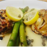 Colossal Crab Cakes · Served with grilled asparagus in a lemon caper sauce.