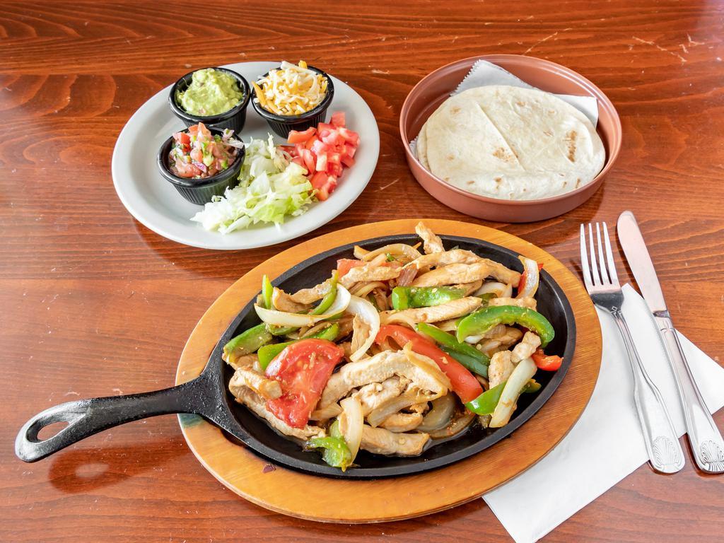 Sizzling Chicken Fajitas · Marinated chunks of a breast of chicken, onions, fresh bell peppers, tomatoes, green peppers, lettuce, chopped tomatoes, and combined eaten like a taco.