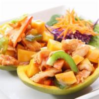 Mango Chicken · Diced mango and bell peppers with sweet and sour sauce on a bed of mango shell.