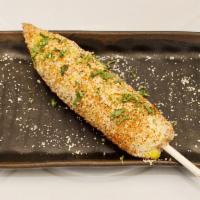 Elote · Roasted ear of corn seasoned with chili spices and finished with chipotle sauce and queso co...