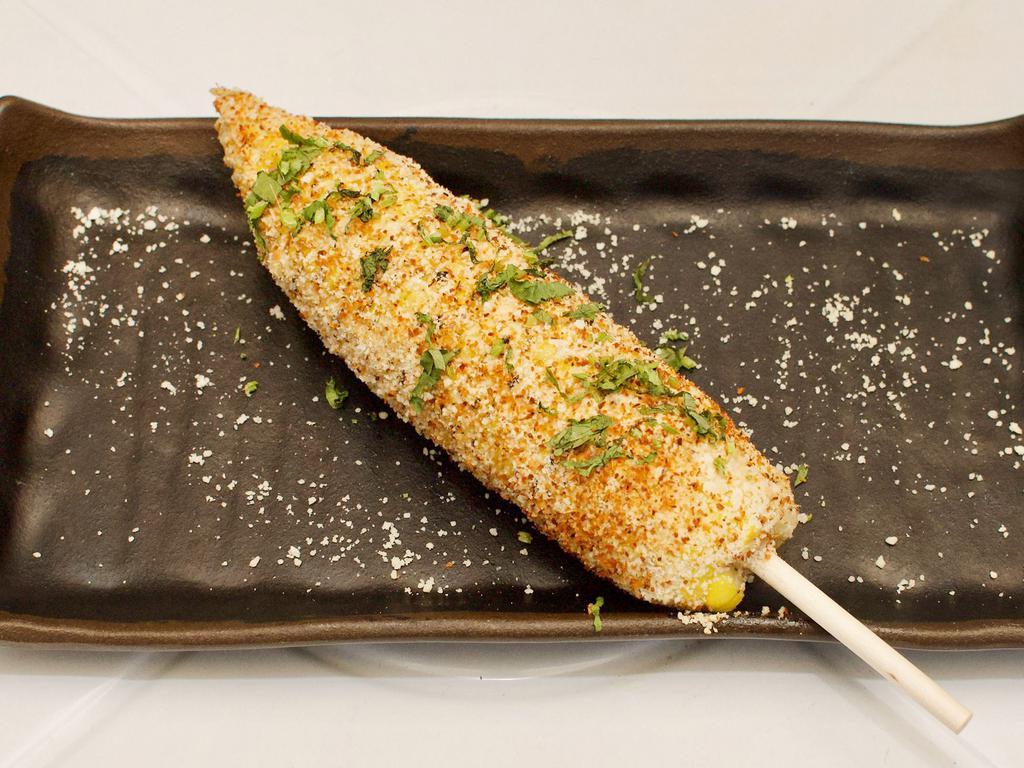 Elote · Roasted ear of corn seasoned with chili spices and finished with chipotle sauce and queso cotija.