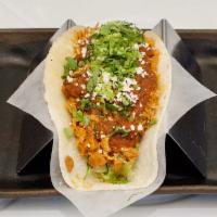 Chicken Tinga Taco · Braised chicken cooked in traditional salsa tinga with shredded romaine, cilantro and queso.