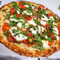 Neapolitan Prosciutto Pizza · Bianca sauce, sliced tomato, fresh mozzarella, prosciutto, fresh basil, Parmesan cheese.