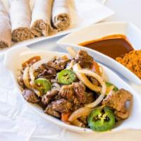 Tibs · Chunks of beef sautéed with onions, tomatoes, jalapenos, garlic and house sauce.