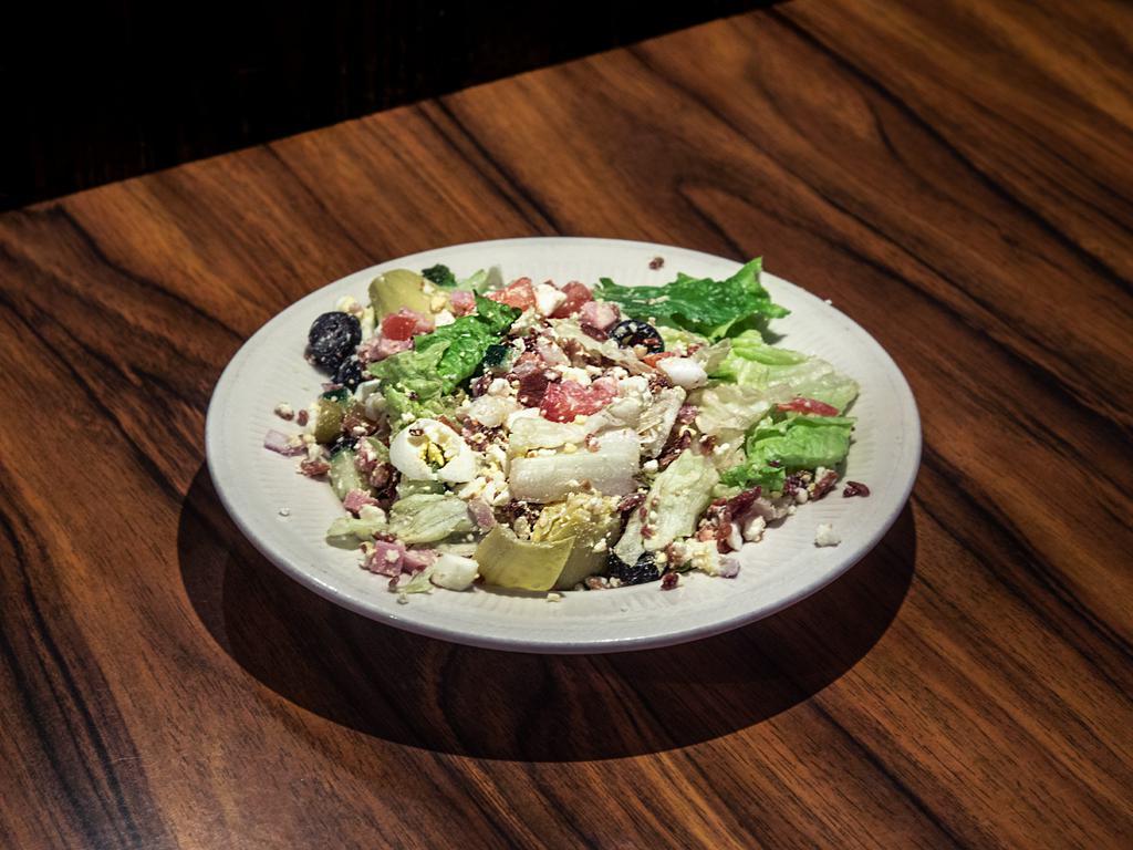 Chopped Salad · Chopped romaine, green and black olives, artichoke hearts, feta cheese, diced egg, tomatoes, ham, red onion, bacon, and cucumbers, tossed in balsamic vinaigrette.