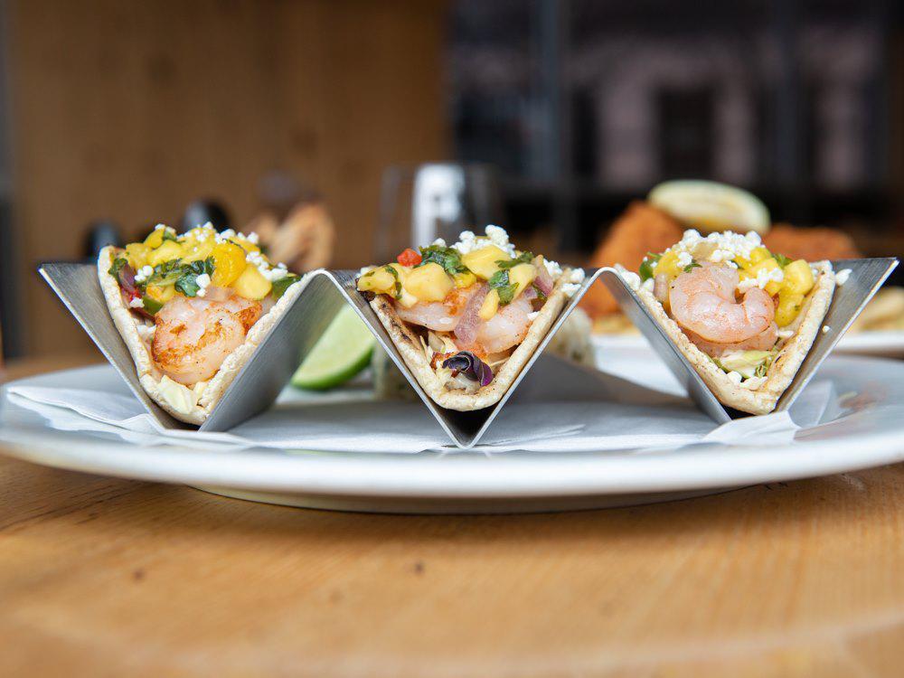Mango Shrimp Tacos · Fins' favorite. Tequila-lime shrimp, cabbage, mango jalapeno salsa, Cotija, Fins' key lime aioli. Gluten-free.  
