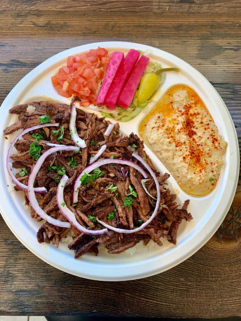 Beef Shawarma Plate · Served with rice, hummus, salad topped with onions and drizzled with tahini sauce. pita bread. 

