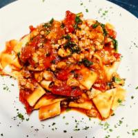 Pappardelle Cavolo, Pomodorini Secchi e Salsiccia · Long wide-cut pasta with kale, sun-dried tomatoes, and sausage, in a light tomato sauce.