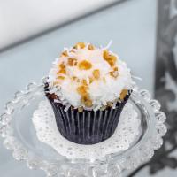 Italian Cream Cupcake · Coconut and walnut cake topped with cream cheese icing, shredded coconut, and walnut pieces.