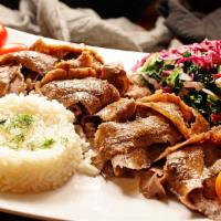 Doner  · Lamb gyro. Layers of marinated ground meat wrapped around the large vertical split and grill...