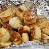 Parmesan Garlic Knots · Made to order dough knots smothered in garlic butter topped with Parmesan, served with marin...