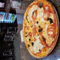 Margherita · Fresh mozzarella, Fresh basil, Fresh Tomato and pizza sauce .