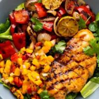 Chicken Cajun-Mango Salad Bowl · Grilled cajun flavored diced chicken, peppers, onions, on a bed of fresh green salad and dri...
