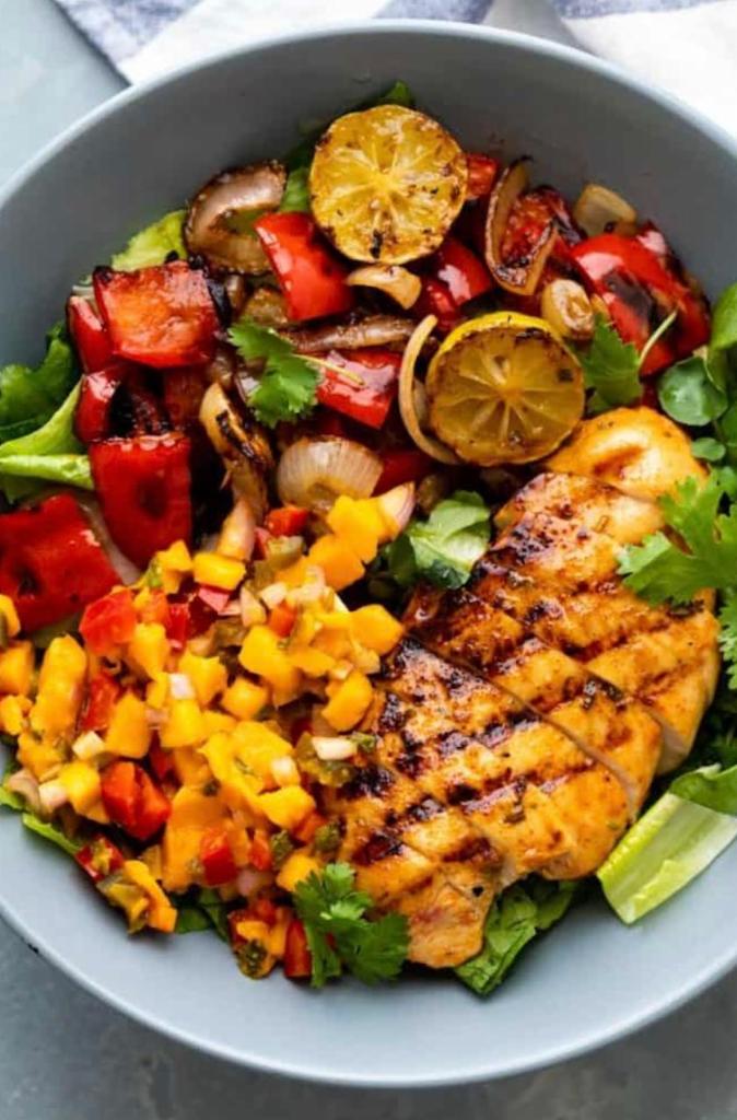 Chicken Cajun-Mango Salad Bowl · Grilled cajun flavored diced chicken, peppers, onions, on a bed of fresh green salad and drizzled with mango ranch salsa.