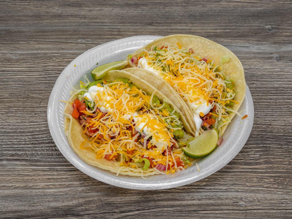 Veggie Tacos · Topped with refried beans, rice, fresh guacamole, sour cream, lettuce, cheese, and pico de gallo.