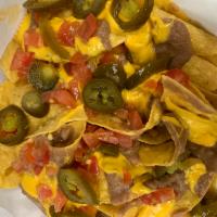 Nachos · Topped with refried beans, nacho cheese sauce, nacho jalapenos, and tomatoes. Sour cream ser...