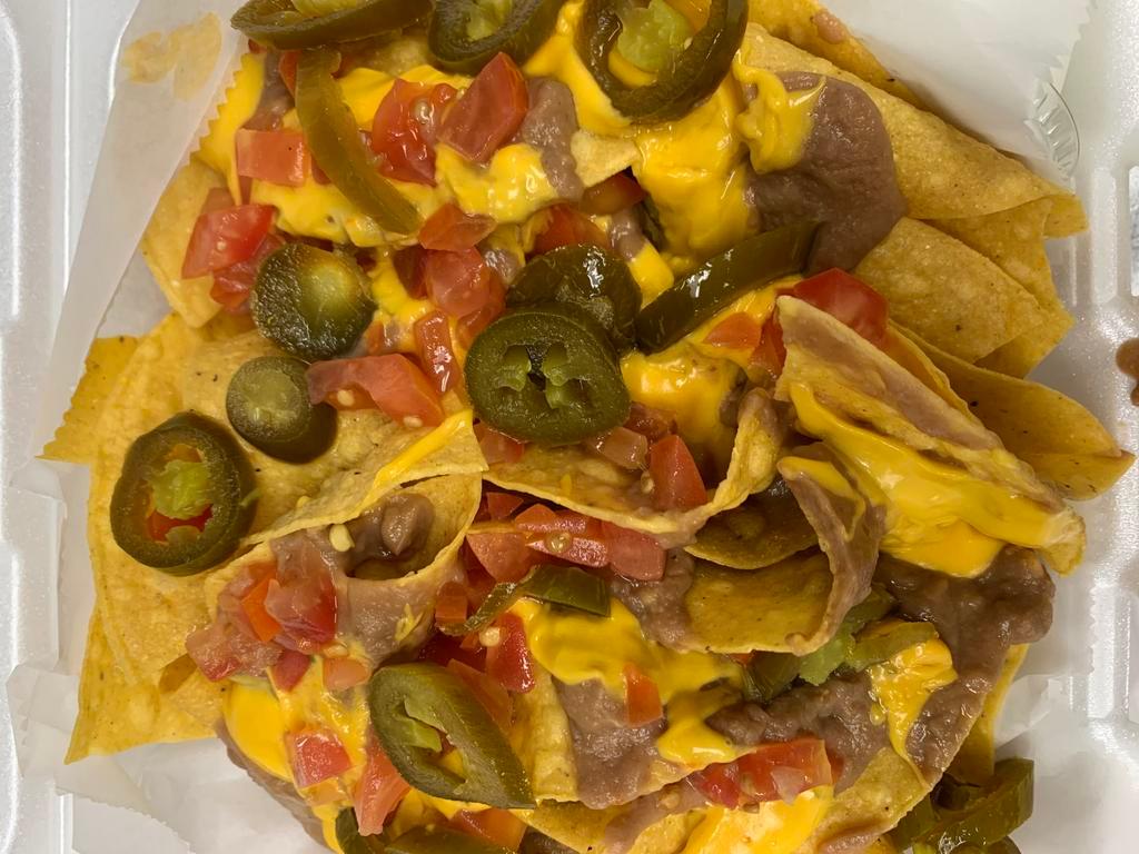 Nachos · Topped with refried beans, nacho cheese sauce, nacho jalapenos, and tomatoes. Sour cream served on the side. Add homemade beef or Homemade chicken for an additional charge. Add a side of homemade guacamole, hot salsa or mild chunky salsa for an additional charge.