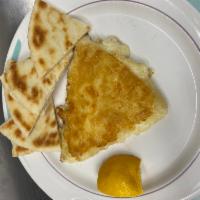 Homemade Saganaki · Flamed cheese, ignited with brandy and freshly squeezed lemon. Served with a pita bread.