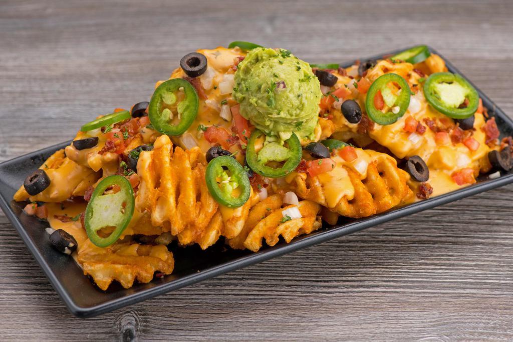 Loaded Nachos · queso • cheddar cheese • bacon •
black olive • pico de gallo • chili •
house made guac • pickled jalapeno
Tortilla Chips or Regular fries
*Shown with waffle fry upgrade